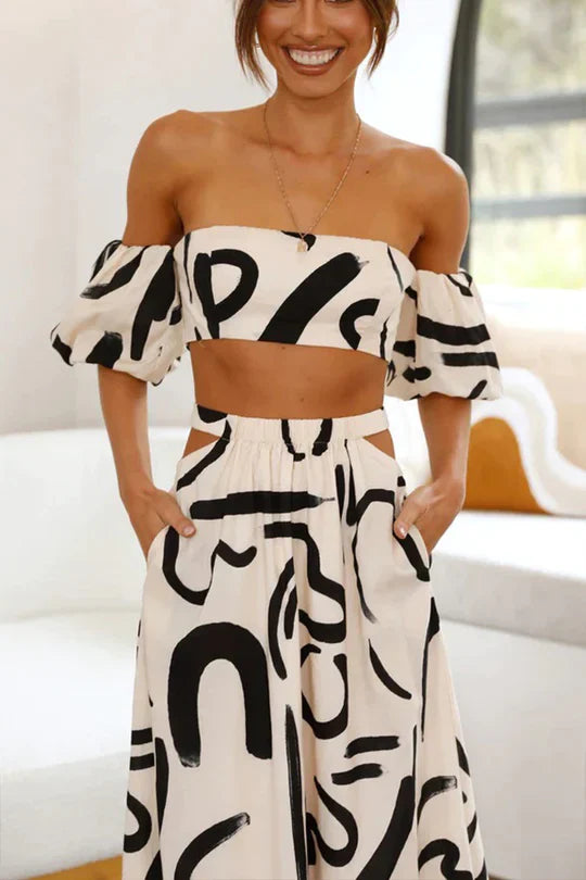 Matching set with printed off-shoulder top and maxi skirt with cutouts and pockets, perfect for a cool and fashionable summer look